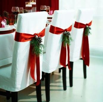Doskonałym elementem dekoracyjnym są czerwone wstążki na krzesłach ozdobione gałązkami choinki i szyszkami (źródło: pinterest)