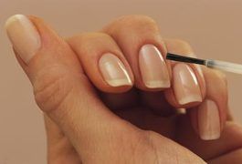 domowe manicure - nakładanie pędzelkiem bezbarwnego olejku zmiękczającego na skórki 