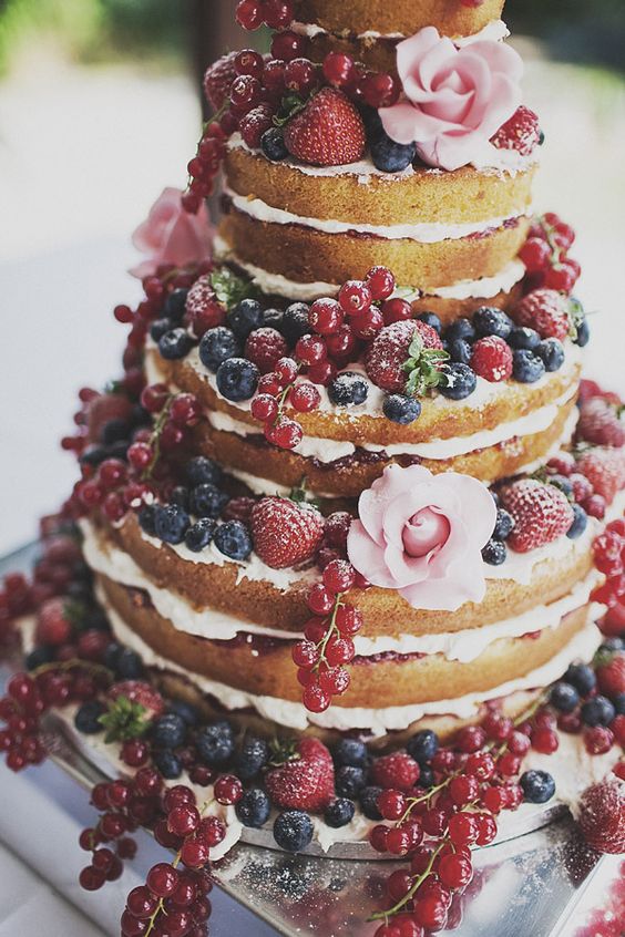 naked cake, wielopoziomowy tort bez polewy i masy plastycznej, z widocznymi warstwami przełożonymi kremem i owocami truskawki, porzeczki i borówki 