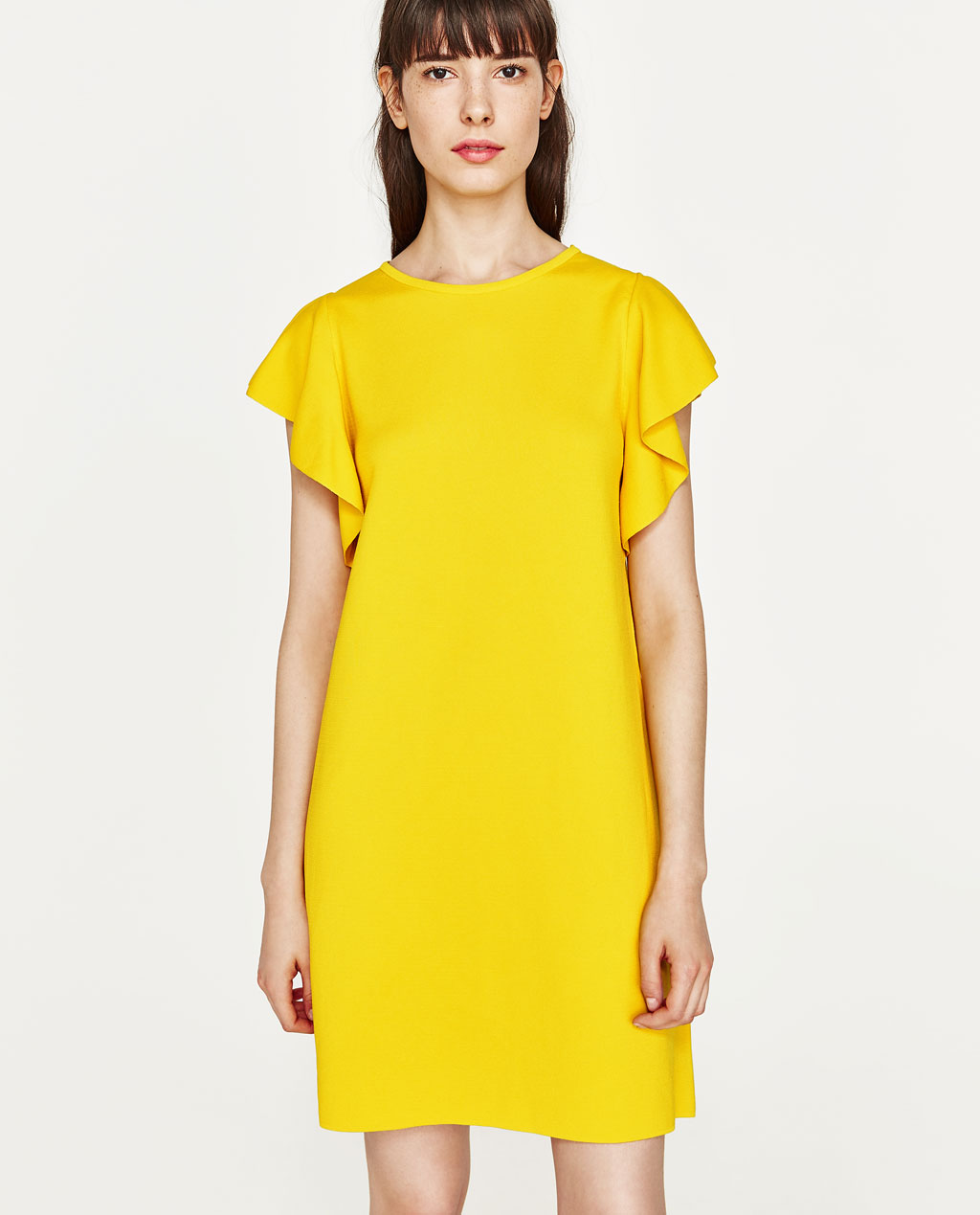 żółta minimalistyczna do połowy uda sukienka na wesele z falbaniastymi rękawkami